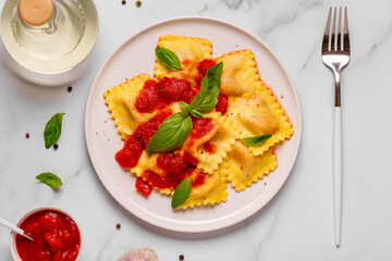 Delicious appetizing ravioli with tomato sauce and basil