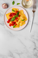 Delicious appetizing ravioli with tomato sauce and basil