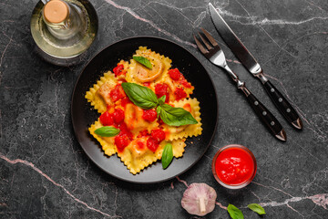 Delicious appetizing ravioli with tomato sauce and basil