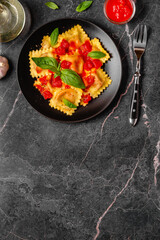 Delicious appetizing ravioli with tomato sauce and basil