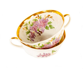 Porcelain teacups with flowers isolated on white background