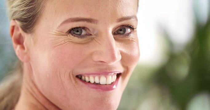 Portrait of smiling, happy face of a mature woman with bokeh background. Mature lady showing dentures and cheerful facial expression with clean white teeth showing healthy oral and dental hygiene
