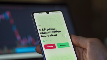 Un investisseur analyse un fonds etf s&p petite capitalisation 600 valeur sur un graphique. Un t&eacute;l&eacute;phone affiche le cours de l'ETF. Texte en fran&ccedil;ais francais S&P petite capitalisation 600 valeur