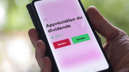 Un investisseur analyse un fonds etf appréciation du dividende sur un graphique. Un téléphone affiche le cours de l'ETF. Texte en français francais appréciation du dividende