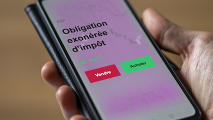 Un investisseur analyse un fonds etf obligation exonérée d'impôt sur un graphique. Un téléphone affiche le cours de l'ETF. Texte en français francais Obligation exonérée d'impôt