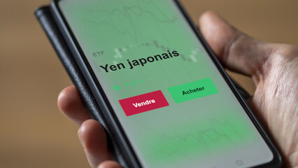 Un investisseur analyse un fonds etf yen japonais sur un graphique. Un téléphone affiche le cours de l'ETF. Texte en français francais yen japonais