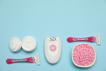 Flat lay composition with epilator and other hair removal products on light blue background. Space...