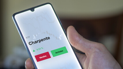 Un investisseur analyse un fonds etf charpente sur un graphique. Un téléphone affiche le cours de l'ETF. Texte en français francais Charpente