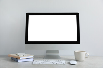 Modern computer with blank screen on light grey table. Mockup for design