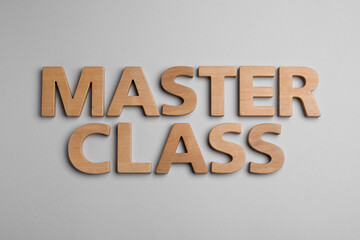 Words Master Class made of wooden letters on light grey background, flat lay