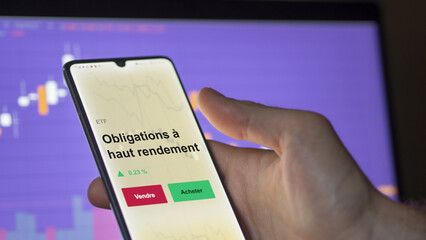 Un investisseur analyse un fonds etf obligations à haut rendement sur un graphique. Un téléphone affiche le cours de l'ETF. Texte en français francais Obligations à haut rendement
