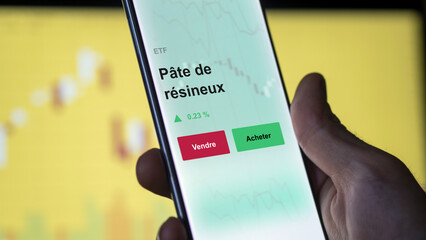 Un investisseur analyse un fonds etf pâte de résineux sur un graphique. Un téléphone affiche le cours de l'ETF. Texte en français francais Pâte de résineux