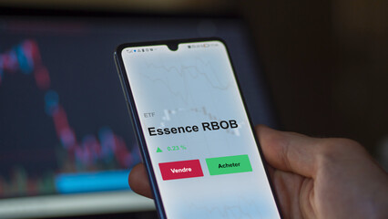 Un investisseur analyse un fonds etf essence rbob sur un graphique. Un téléphone affiche le cours de l'ETF. Texte en français francais Essence RBOB