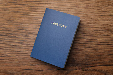 Blank blue passport on wooden table, top view