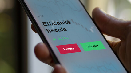 Un investisseur analyse un fonds etf efficacité fiscale sur un graphique. Un téléphone affiche le cours de l'ETF. Texte en français francais Efficacité fiscale