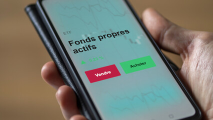 Un investisseur analyse un fonds etf fonds propres actifs sur un graphique. Un téléphone affiche le cours de l'ETF. Texte en français francais Fonds propres actifs