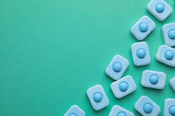 Water softener tablets on turquoise background, flat lay. Space for text