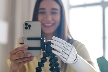Girl blogger disability bionic arm using phone, live streaming social media at home, disabled...