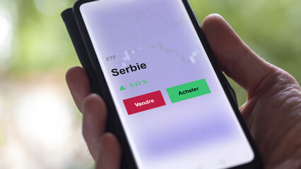 Un investisseur analyse un fonds etf serbie sur un graphique. Un téléphone affiche le cours de l'ETF. Texte en français francais Serbie