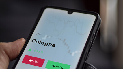 Un investisseur analyse un fonds etf pologne sur un graphique. Un téléphone affiche le cours de l'ETF. Texte en français francais Pologne