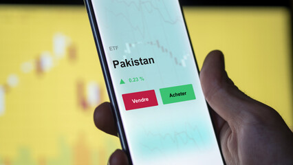 Un investisseur analyse un fonds etf pakistan sur un graphique. Un téléphone affiche le cours de l'ETF. Texte en français francais Pakistan
