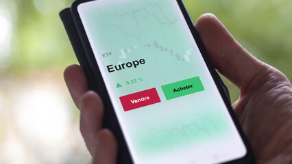 Un investisseur analyse un fonds etf europe sur un graphique. Un téléphone affiche le cours de l'ETF UE marché européen. Texte en français francais