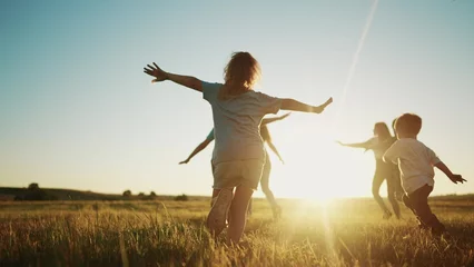 Fotobehang Slaapkamer kids run in the park at sunset. friendly family children camp kid dream concept. a group of children run on the grass at fun the rays of the sun silhouette. childhood sunset dream teamwork concept  © maxximmm