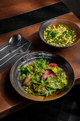 Salad with meat, arugula, frisse salad and soup