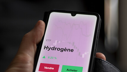 Un investisseur analyse un fonds etf hydrogène sur un graphique. Un téléphone affiche le cours de l'ETF. Texte en français francais Hydrogène