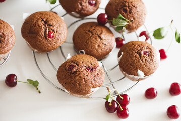 Fototapeta na wymiar Homemade baked cherry muffins with fresh berries on white wooden table