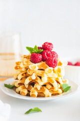 Homemade baked Belgian ricotta waffles with fresh berries on white wooden table