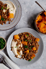 Vegan healthy food. Lentils and butternut squash with houmus and green herbs, clean eating concept