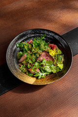 Salad with meat, arugula, frisse salad, cucumber