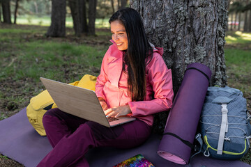 traveler mature woman, in forest with laptop, biologist using laptop in camping nature