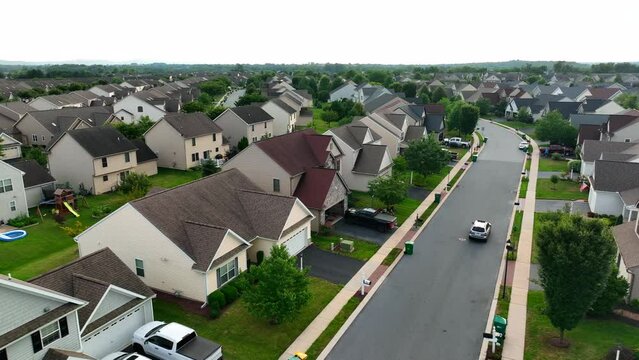 Aerial of USA neighborhood houses. SUV car drives on street.