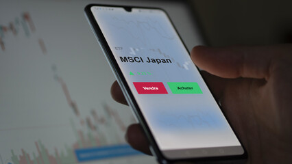 Un investisseur analyse un fonds etf msci japan sur un graphique. Un téléphone affiche le cours de l'ETF. Texte en français francais MSCI Japan