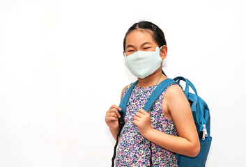 Portrait happy Asian child girl with facemask, carrying backpack to go to school, Asian student child in 7 to 9 years old, isolated portrait image on white background. Concept for back to school