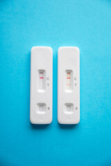 Coronavirus antigen rapid tests device, with positive and negative result on a blue background. Copy space.