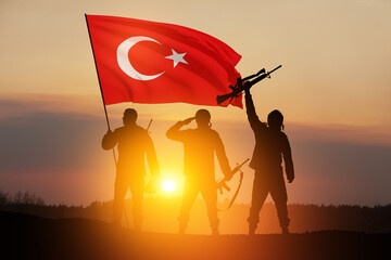 Silhouettes of soldiers with Turkey flag against the sunrise or sunset. Concept of crisis of war...
