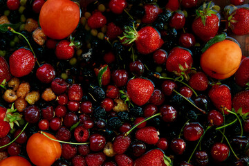 Summer fruits and berries background: apricots, strawberries, cherries, mulberry, currant, raspberries. Healthy food, natural dessert, organic eating