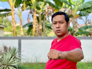 Young man in red shirt looking at camera showing high spirit