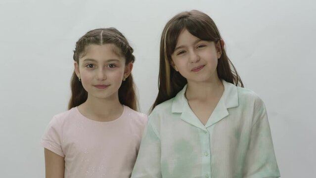 Portrait of two beautiful little girls on a white background. Cute little girls sending kisses on white background. Little girls send kisses to their parents.