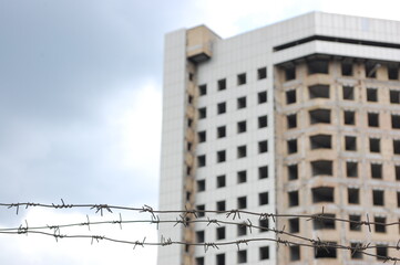Barbed wire on the background of an unfinished or destroyed house.The concept of safe security in...
