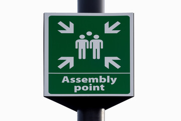 Emergency evacuation assembly point sign close up isolated against white background. 