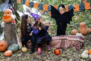 happy kids in halloween costumes having fun in halloween decorations outdoor