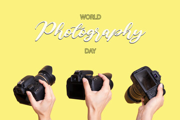 World Photography Day text and camera in hands on yellow colored background