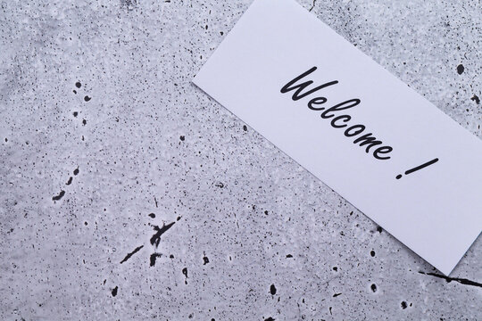 The photo shows a label with the inscription "welcome" on a grey background