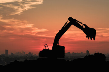 Crawler excavators silhouette are digging the soil in the construction site on the sunset...