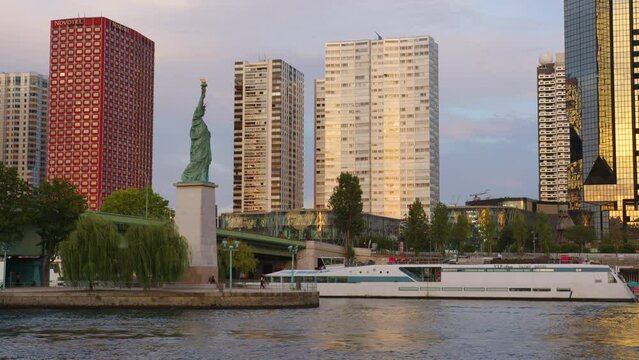The Statue of Liberty in the Paris. View from Mirabeau bridge before sunset. Paris, France. Statue of Liberty against the backdrop of skyscrapers at sunset