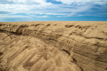 Fototapeta na wymiar Scenic landscape. Sandy shore. Sand rock. Cloudy sky